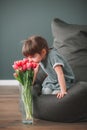 Cute little girl sniffing pink tulips