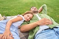 Cute little girl spending time together with her father, relaxing, lying down on a blanket in the beautiful green park Royalty Free Stock Photo