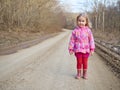 Cute little girl standing on a forest road Royalty Free Stock Photo