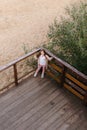 little girl stands alone on a wooden veranda