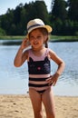 cute little girl in a straw hat on the beach, playing with water, swimming, sunbathing. tourist enjoys free time outdoor Royalty Free Stock Photo