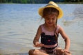 cute little girl in a straw hat on the beach, playing with water, swimming, sunbathing. tourist enjoys free time outdoor Royalty Free Stock Photo