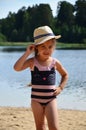 cute little girl in a straw hat on the beach, playing with water, swimming, sunbathing. tourist enjoys free time outdoor Royalty Free Stock Photo