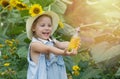 A cute little girl in a straw hat holds a glass bottle of sunflower oil in her hands and laughs cheerfully. Cheerful Royalty Free Stock Photo