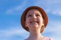 Cute little girl in a straw hat with ice cream on the face after eating on blue sky background. Child on the sea beach Royalty Free Stock Photo