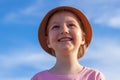 Cute little girl in a straw hat with ice cream on the face after eating on blue sky background. Child on the sea beach Royalty Free Stock Photo