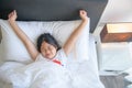 Cute little girl stretching her arms happily from waking up in her bed Royalty Free Stock Photo