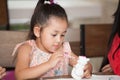 Cute little girl student painting a ceramic pottery model  in classroom school . kid artist . child sitting at desk preschool . Royalty Free Stock Photo