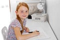 A Cute little girl studying at home and smiling Royalty Free Stock Photo