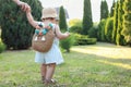 Cute little girl in stylish clothes holding mother`s hand outdoors on sunny day, back view. Space for text Royalty Free Stock Photo