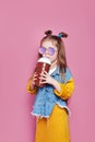 Cute little girl in sunglasses with glass jar of cocktail chilling on pink background Royalty Free Stock Photo