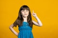 Cute little girl is surprised and raised her index finger up. An idea has come or points to a place for an inscription Royalty Free Stock Photo