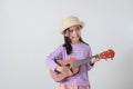 Cute little girl in swimsuit playing ukulele Royalty Free Stock Photo