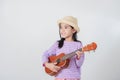 Cute little girl in swimsuit playing ukulele Royalty Free Stock Photo