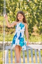 Cute little girl on a swing. Smiling child playing outdoors in summer. Happy kids swinging at the park. Happy kid having Royalty Free Stock Photo