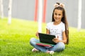 Cute little girl tablet PC in the park Royalty Free Stock Photo