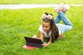 Cute little girl tablet PC in the park Royalty Free Stock Photo