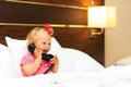 Cute little girl taking on the phone in hotel room Royalty Free Stock Photo