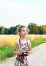 Cute little girl taking pictures with old film camera. Pretty c Royalty Free Stock Photo