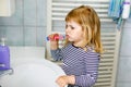 Cute little girl with a toothbrush in her hand cleans her teeth and smiles. Funny happy healthy child learning morning Royalty Free Stock Photo