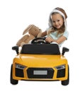 Cute little girl with toy bunny driving children`s car on white background Royalty Free Stock Photo