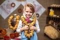 Cute little girl in a traditional Russian headscarf and sundress with bunch of bagels. Royalty Free Stock Photo