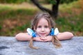 Cute little girl with two pigtails on her head fold hands near face. Concept of happy childhood and summer leisure. Smiling child Royalty Free Stock Photo