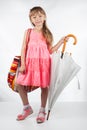 Cute little girl with umbrella and bag on her shoulder posing on a white background Royalty Free Stock Photo