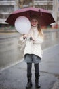 Cute little girl with an umbrella in the rain