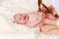 A cute little girl up to a year old lies on her back and laughs. mother and little daughter play. . eight months Royalty Free Stock Photo