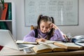 Cute little girl using laptop to study online at home. Royalty Free Stock Photo