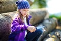 Cute little girl using a pocket knife to whittle a stick for a forest hike Royalty Free Stock Photo