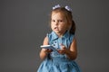 Cute little girl using smartphone. Gray background Royalty Free Stock Photo