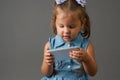 Cute little girl using smartphone. Gray Background Royalty Free Stock Photo