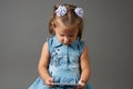 Cute little girl using smartphone. Gray background Royalty Free Stock Photo