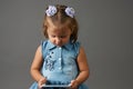 Cute little girl using smartphone. Gray Background Royalty Free Stock Photo