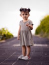 Cute little girl walking along the promenade near the beach. Warm sunny day. Summer vacation. Holiday concept. Asian baby girl Royalty Free Stock Photo