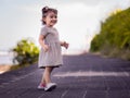 Cute little girl walking along the promenade near the beach. Warm sunny day. Summer vacation. Holiday concept. Baby girl wearing Royalty Free Stock Photo