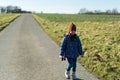 Cute little girl walking on a country road on a sunny day Royalty Free Stock Photo