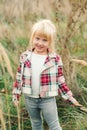 Cute little girl walking at countryside. Fashionable little girl with blue eyes and blondy hair. Kids fashion. Happy child at