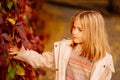 cute little girl by wall with autumn wild grapes. beauty of autumn nature. Royalty Free Stock Photo