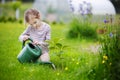 Cute little girl watering plants in garden Royalty Free Stock Photo