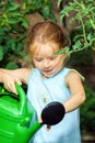 Cute little girl watering tomato and flowers in the backyard Royalty Free Stock Photo