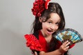 Cute little girl wearing beautiful red and black dress with matching head band, posing for camera using chinese hand fan