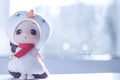 Cute little girl wearing white hat and red scarf like a snowman preparing for christmas in front of a window in winter Royalty Free Stock Photo