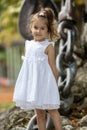 Cute little girl in white dress, posing and smiling Royalty Free Stock Photo