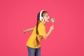 Cute Little Girl In Wireless Headphones Singing With Lollipop In Hands