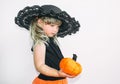 Cute little girl in witch costume with pumpkins. Halloween. On a white background. Royalty Free Stock Photo