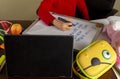 A cute little girl is writing sentences on a white board using blue marker.