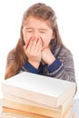 Cute little girl yawning in front of books Royalty Free Stock Photo